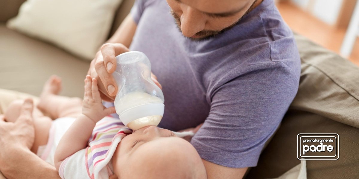Padre alimentando a su bebé con biberón.
