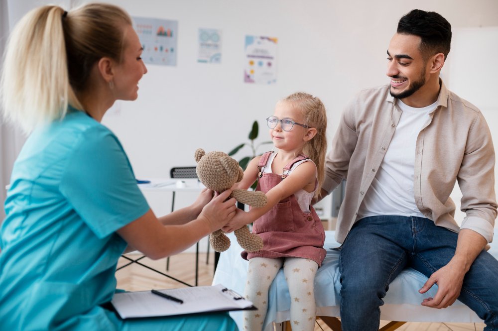 Padre e hija en consulta pediátrica de urgencias, recibiendo orientación médica.